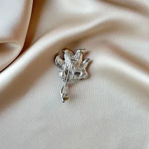 Silver tone metal flower brooch back detail, vintage style accessory pin for women.