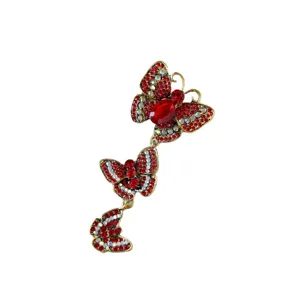 Vintage antique gold brooch featuring three linked butterflies with red rhinestones