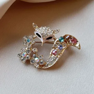 Chic gold-tone fox brooch featuring sparkling crystal rhinestones and enamel details. Perfect accessory.