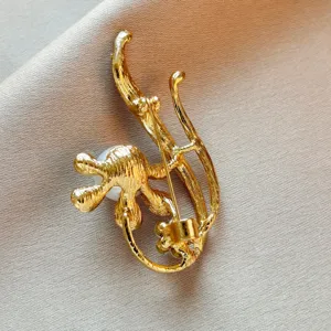 Detailed back view of vintage golden pearl flower brooch showing secure pin closure