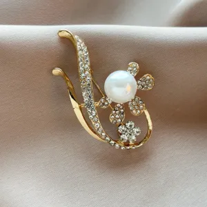 Detailed view of an elegant pearl flower brooch with rhinestone inlay and gold finish
