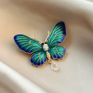 Detailed macro shot of an elegant teal enamel butterfly brooch with crystal accents