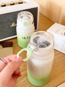 Vue détaillée de la jolie bouteille isotherme dégradée verte avec paille et poignée portable.