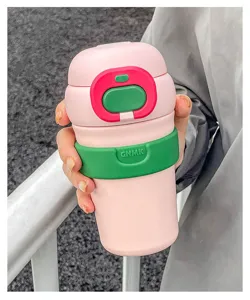 Detailed shot of a stylish pink dopamine insulated travel mug with green silicone sleeve.