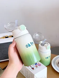 Vue détail de la jolie bouteille thermos dégradée avec paille et motif de lettres tendance.