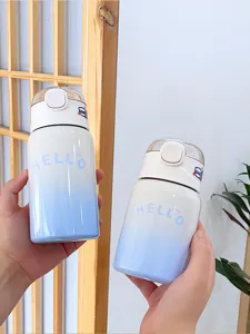 Gros plan de la bouteille thermos pour enfants dégradé bleu avec paille et design mignon.