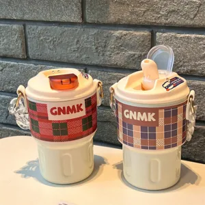 Close-up of two ins-style portable coffee thermoses with plaid sleeves and straps