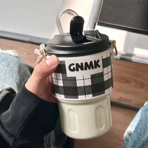 Close-up of portable 316 stainless steel coffee thermos with checkered sleeve and strap