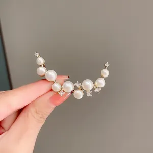 Pearl crescent brooch detail shot, showing exquisite metalwork and shining cubic zirconia accents.