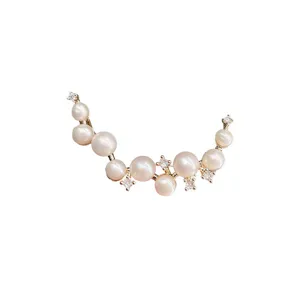 Detailed view of elegant crescent pearl brooch featuring sparkling zirconia, chic accessory.