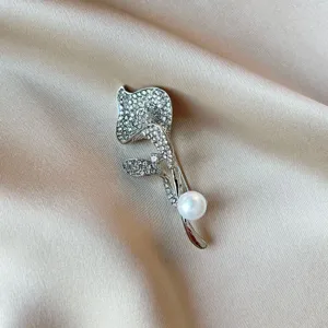 Elegant silver-toned floral brooch pin with sparkling rhinestones and a white pearl accent.
