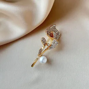 Exquisite rhinestone calla lily brooch detail, gold-plated metal with elegant white pearl accent.