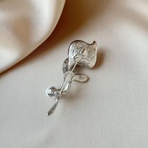 Silver brooch pin detail showing secure clasp backing and delicate floral metal craftsmanship.
