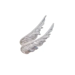 Detailed view of silver angel wings brooch fully encrusted with shimmering crystals.