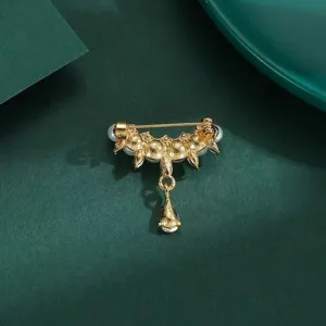 Detailed view of the exquisite gold-toned pearl and teardrop tassel brooch back structure.