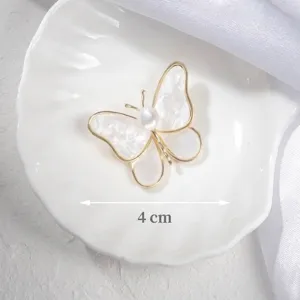 Detailed close-up of an elegant white butterfly brooch with a 4cm width measurement