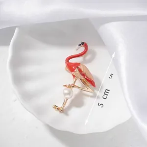 Detailed macro view of an elegant flamingo brooch with red enamel and pearl