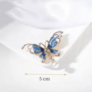 Detailed view of elegant blue butterfly brooch with pearl charm, 5cm size dimension.