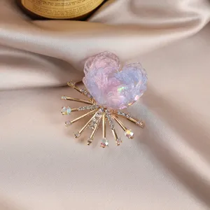 Exquisite colorful flower crystal brooch with rhinestone rays, elegant silk background detail.