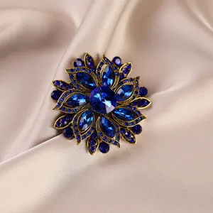 Close-up detail of vintage blue crystal floral brooch, exquisite alloy setting for women fashion.