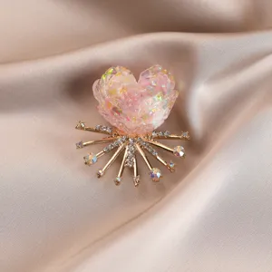Exquisite colorful floral brooch detail, shimmering crystal heart design with radiant gold metal base.