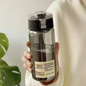 Detailansicht einer minimalistischen rauchgrauen Trinkflasche mit Etikett in der Hand