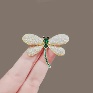 Exquisite rhinestone dragonfly brooch detail, showcasing sparkling crystal gems and gold tone metal.