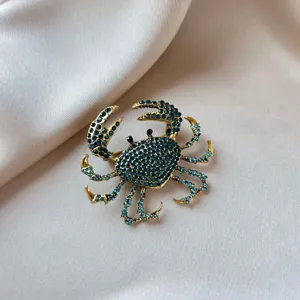 Elegant gold-tone crab brooch pin embellished with sparkling teal rhinestones for women