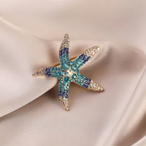 Detailed close-up of a sparkling multi-color rhinestone starfish brooch on satin fabric.