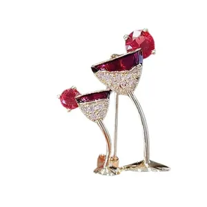 Elegant gold-toned wine glass brooch with shimmering red and white crystals for women.
