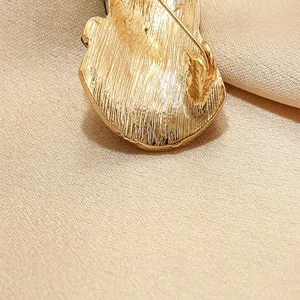 Gold-tone brooch pin back detail shot, elegant decorative lapel accessory.