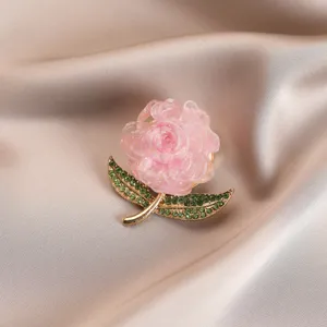 Exquisite pink peony flower brooch with sparkling green rhinestone leaves and gold finish.