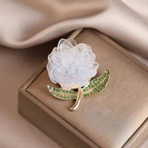 Exquisite peony flower brooch with sparkling green rhinestone leaves and delicate translucent petals.