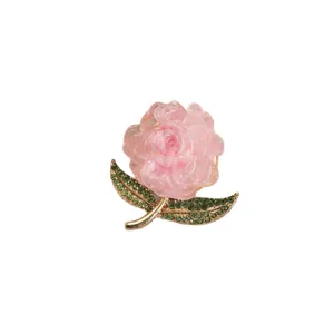 Pink flower brooch with green crystal leaves and gold metal base for women's apparel.