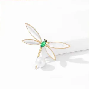 Exquisite pearl dragonfly brooch featuring green crystal body and elegant pearl wings.