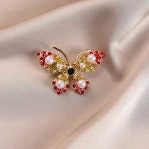 Detailed view of an elegant butterfly brooch with colorful rhinestones and pearls