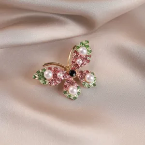 Detailed macro view showing the pink rhinestone and pearl accents on this butterfly brooch