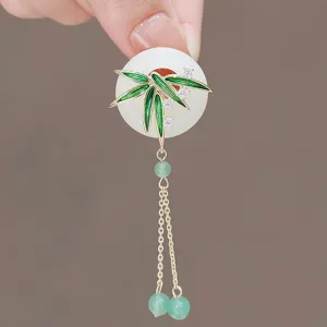 Primer plano detallado de broche de borla de bambú con hebilla de paz de jade estilo chino.