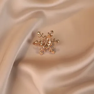 Macro detail showing the secure back pin mechanism of the golden snowflake brooch accessory