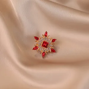 Macro view of a luxury vintage brooch with red and white crystal petals on silk