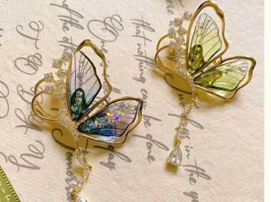 Exquisite detail of translucent butterfly brooch featuring sparkling rhinestones and tassels.