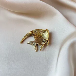 Gold alloy fish brooch detail view, elegant metal animal pin and scarf buckle accessory.