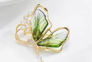 Detailed view of fresh forest style translucent green butterfly brooch with sparkling cubic zirconia.