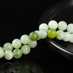 Primo piano di perle tonde in giada Xiuyan verde chiaro naturale per gioielli DIY