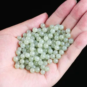 Close-up detail of light green natural Hetian jade loose beads for DIY jewelry making.