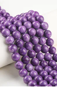 Close-up view of imitation charoite purple beads showing silky texture for jewelry DIY