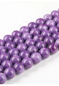 Macro detail of purple imitation Charoite beads with swirling silk patterns for DIY.