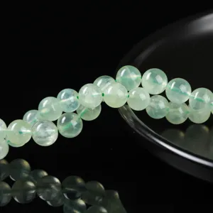 Primo piano di perle tonde in prenite verde naturale per la creazione di gioielli fai-da-te