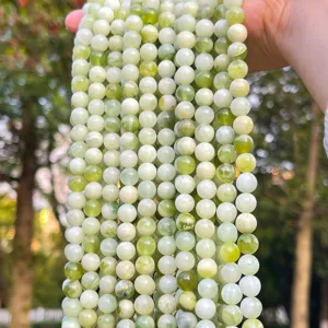Primo piano di perle naturali in giada Xiu verde chiaro con texture lattiginosa