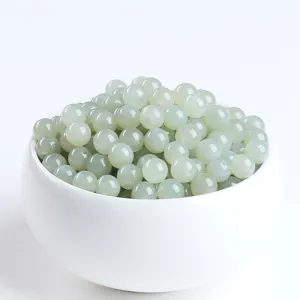 Macro shot of natural light green Hetian jade loose beads for DIY jewelry making